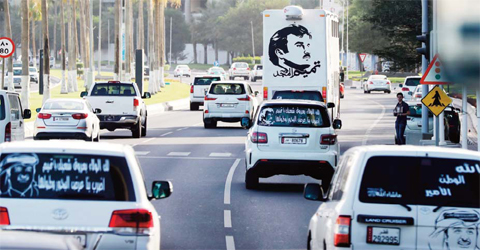 DOHA: A general view taken on June 11, 2017 shows portraits of Qatar’s Emir Sheikh Tamim bin Hamad Al-Thani on the back of vehicles and text reading in Arabic: “Tamim the glorious”. —AFP