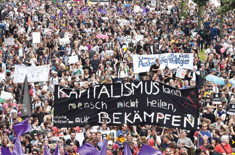 HAMBURG: Protesters hold a banner reading “capitalism cannot be healed by people but battled” during the “solidarity without borders instead of G20” demonstration yesterday in Hamburg, northern Germany as world leaders meet during the G20 summit. — AFP
