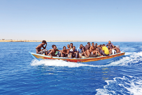 TRIPOLI: Libyan coastguards help rescue illegal immigrants attempting to reach Europe off the coastal town of Guarabouli, 60 kilometers east of the capital. — AFP
