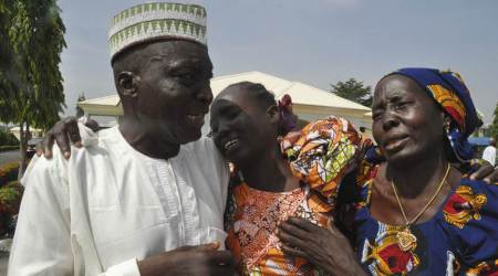 Family members celebrate as they embrace a relative, one of the released kidnapped schoolgirls, in Abuja, Nigeria, Saturday, May 20, 2017. ﻿The 82 Nigerian schoolgirls recently released after more than three years in Boko Haram captivity reunited with their families for the first time Saturday, as anxious parents looked for signs of how deeply the extremists had changed their daughters' lives. (AP Photo/Olamikan Gbemiga)