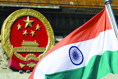 File - In this Wednesday, Oct. 23,2013, file photo, an Indian national flag is flown next to the Chinese national emblem during a welcome ceremony for visiting Indian officials outside the Great Hall of the People in Beijing. India says it is ready to hold talks with China with both sides pulling back their forces to end a standoff along a disputed territory high in the Himalayan mountains. (AP Photo/Andy Wong, File)