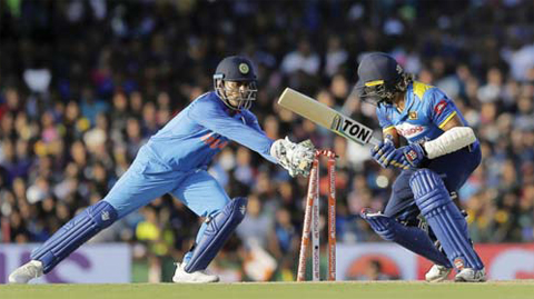 DAMBULLA: India’s wicketkeeper Mahendra Singh Dhoni, left, stumps out Sri Lanka’s Lasith Malinga, right, during their first one-day international cricket match in Dambulla, Sri Lanka, yesterday. —AP