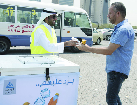 Kuwait International Bank staff distributes cold refreshments and water during the hot summer. 