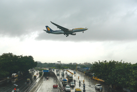 MUMBAI: An aircraft of India’s Jet Airways lands during rain showers yesterday. —AFP