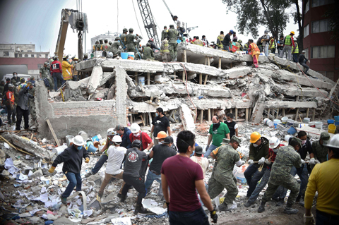  MEXICO CITY: Rescuers, firefighters, policemen, soldiers and volunteers search for survivors in a flattened building in Mexico City yesterday a day after a strong quake hit central Mexico.- AFP 