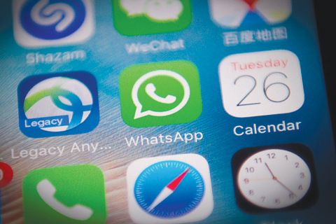 This photo illustration shows the WhatsApp application logo (C) on a smartphone screen in Beijing yesterday. Chinese authorities appear to have severely disrupted the WhatsApp messaging app in the latest step to tighten censorship as they prepare for a major Communist Party congress next month.—AFP