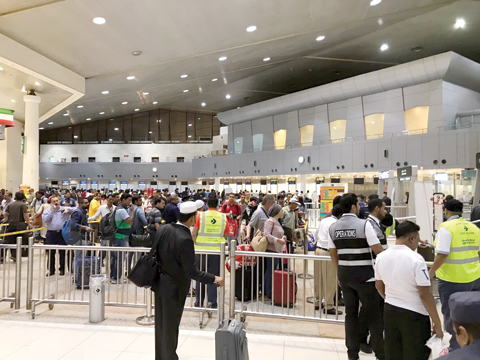 KUWAIT: This file photo shows passengers lined up at Kuwait International Airport. Increased fees on public health services presented to expatriates in Kuwait could threaten to hurt tourism in the Gulf state. — KUNA