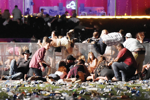   LAS VEGAS: People scramble for shelter at the Route 91 Harvest country music festival after gunfire was heard on Sunday. - AFP 