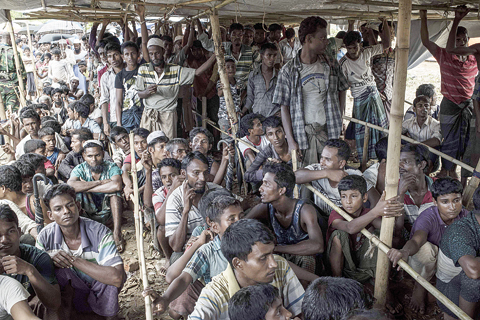 UKHIA, Bangladesh: Rohingya refugees wait in line during a food distribution at the Thangkhali refugee camp in the Bangladeshi district of Ukhia yesterday. —AFP
