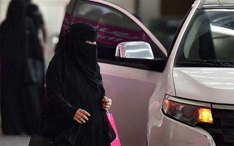 A Saudi woman walks past a car outside a hotel in the Saudi capital Riyadh, on September 28, 2017 - AFP