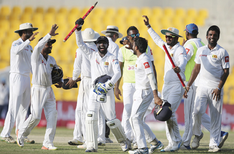   ABU DHABI: File photo of Sri Lanka players celebrate after they beat Pakistan during their fifth day at First Test cricket match in Abu Dhabi, United Arab Emirates, Monday. - AP