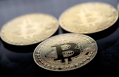 LONDON: This file photo taken on November 20, 2017 shows gold plated souvenir Bitcoin coins arranged for a photograph in London. Bitcoin, which this week soared to a new record high of more than $8,000, is the monetary equivalent of Uber, since it bypasses central bank regulation and could be attractive for financially fragile countries, economists say. —A