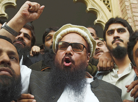 LAHORE: Pakistani head of the Jamaat-ud-Dawa (JuD) organization Hafiz Saeed (center) speaks to the media after his release order outside a court in Lahore yesterday. —AFP