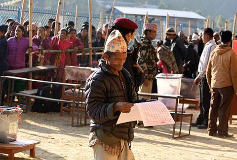 SINDHUPALCHOWK: A Nepali voter examines a ballot papers before casting his vote at a polling station during the general election at Chautara, Sindhupalchowk district yesterday. – AFP 