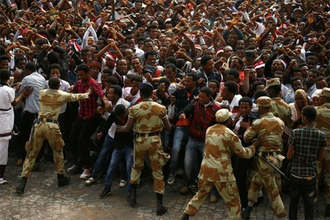 Demonstrators chant slogans while flashing the Oromo protest gesture during Irreecha, in Bishoftu town, Oromiya region, Ethiopia, in this file photo taken October 2, 2016. REUTERS