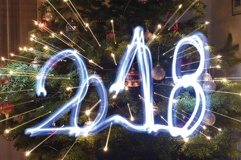 This illustration taken with a long time exposure and with zoom effect in Budapest, Hungary, shows the year ì2018î, painted with a flashlight in front of a Christmas tree