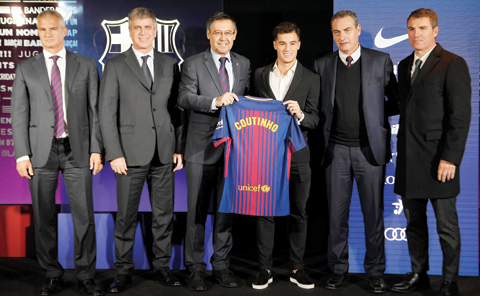 BARCELONA: Barcelona’s new Brazilian midfielder Philippe Coutinho (CR) poses with his new jersey beside Barcelona FC President Josep Maria Bartomeu (CL) during his official presentation in Barcelona yesterday. — AFP