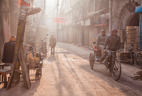 NEW DELHI: An Indian bicycle rickshaw driver pedals down an alleyway on a foggy morning in New Delhi yesterday. —AFP
