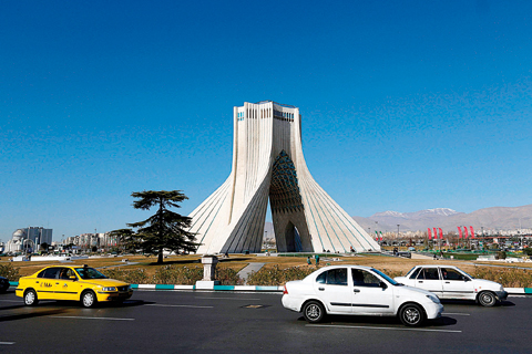 TEHRAN: Iranian motorists drive past the Azadi Tower in the capital Tehran yesterday. —AFP