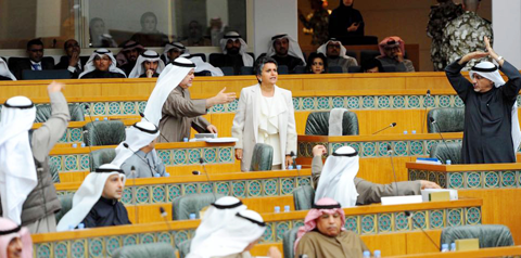 KUWAIT: MP Safa Al-Hashem (center) speaks as MPs Khalil Al-Saleh (left) and Khalil Abul (right) gesture during a raucous National Assembly session yesterday. — Photo by Fouad Al-Shaikh