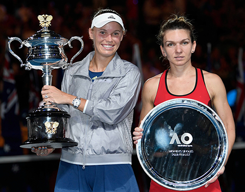 Denmark's Caroline Wozniacki (L) poses with the winner's trophy beside Romania's Simona Halep after their women's singles final match on day 13 of the Australian Open tennis tournament in Melbourne on January 27, 2018. - AFP PHOTO 