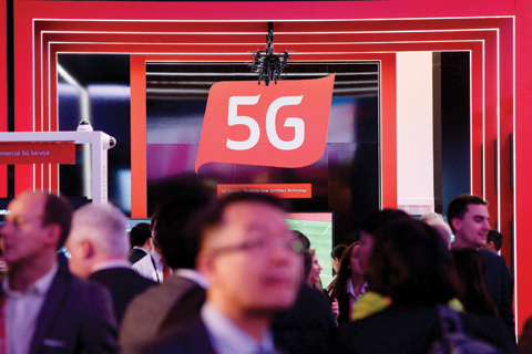 BARCELONA: People walk by a 5G stand at the Mobile World Congress (MWC), the world's biggest mobile fair, on Monday. – AFP 
