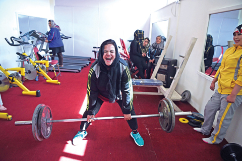 Afghanistan national powerlifting team member Rasheda Parhiz, 40, reacts during a deadlift exercise as teammate Sadya Ayubi looks on during a training session at a women’s gym.— AFP Photos