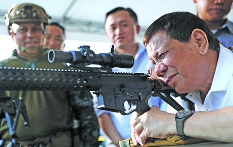 DAVAO CITY: This photo taken and released by Presidential Photographers Division (PPD) on March 1, 2018 shows President Rodrigo Duterte firing a few rounds with a sniper rifle during the opening ceremony of the National Special Weapons and Tactics (SWAT) Challenge. - AFP 