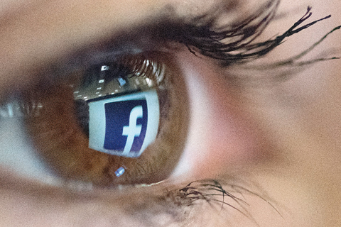 PARIS: An illustration picture taken yesterday in Paris shows a close-up of the Facebook logo in the eye of an AFP collaborator posing while she looks at a flipped logo of Facebook. —AFP