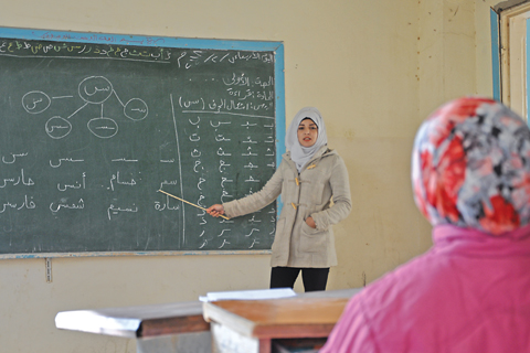 DEIR EZZOR: A Syrian teacher shows letters on a board at school in the village of Al-Shamatiyah on the ourskirts of Deir Ezzor. —AFP