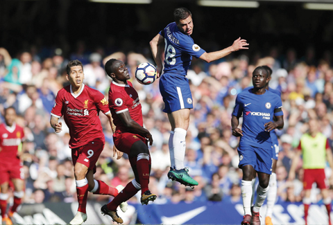 LONDON: Chelsea’s Spanish defender Cesar Azpilicueta (CR) vies with Liverpool’s Senegalese midfielder Sadio Mane (CL) and Liverpool’s Brazilian midfielder Roberto Firmino (L) during the English Premier League football match between Chelsea and Liverpool at Stamford Bridge in London yesterday.— AFP