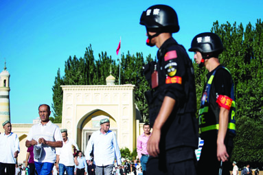 KASHGAR: This file picture shows police patrolling as Muslims leave the Id Kah Mosque after the morning prayer on Eid Al-Fitr in the old town of this city in China's Xinjiang Uighur Autonomous Region. - AFP 