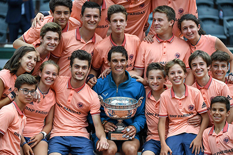 TOPSHOT - Spain's Rafael Nadal (C) poses with the Mousquetaires Cup (The Musketeers) and the ball boys, after his victory over Austria's Dominic Thiem, at the end of the men's singles final match, on day fifteen of The Roland Garros 2018 French Open tennis tournament in Paris on June 10, 2018. / AFP PHOTO / Christophe ARCHAMBAULT