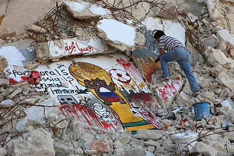 BINNISH, Syria: Syrian graffiti artist Aziz al-Asmar, 35, puts the final touches on his anti-Russian mural painting amid the rubble of a damaged building in the town of Binnish in Syria’s rebel-controlled Idlib province to draw attention to the Russia’s pro-regime role in the Syrian conflict ahead of the upcoming World Cup.-AFP