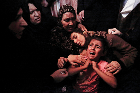 The mother (C) and unidentified relatives of 15-year-old Haitham al-Jamal mourn over his death during his funeral in Rafah in the southern Gaza Strip on June 9, 2018, one day after he was fatally shot by Israeli soldiers. nFour Palestinians were killed by Israeli fire on the Gaza border on June 8, the territory's health ministry said giving a new toll, as weeks of deadly clashes with protesters continued.  / AFP PHOTO / Said KHATIB