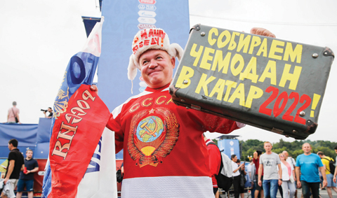 MOSCOW: A supporter holds a suitcase witha text reading “collect suitcase in Qatar 2022!” at the fan Fest in Moscow before the Russia 2018 World Cup final football match between France and Croatia yesterday. — AFP