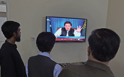 QUETTA: Pakistani men watch a television broadcasting the speech of newly appointed Pakistani Prime Minister Imran Khan as he addresses the nation. — AFP