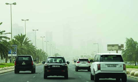 KUWAIT: Vehicles drive through a dust storm that hit Kuwait yesterday. – Photo by Fouad Al-Shaikh