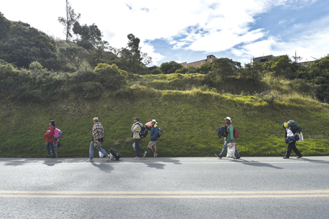 PASTO: Members of Venezuelan migrant families Mendoza Landinez and Lomelly, walk along the Pan-American highway, between Pasto and Ipiales, Colombia, on their way to Peru. — AFP