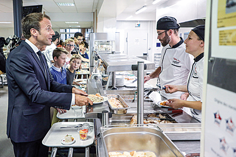 PARIS: French President Emmanuel Macron uses food for lunch at the canteen of a secondary school in Laval, western France, at the start of the school year in France. —AFP