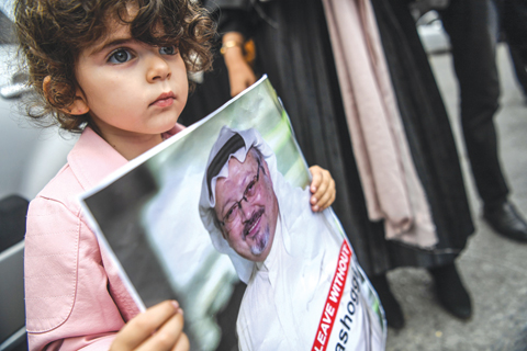 ISTANBUL: A girl holds a picture of missing journalist Jamal Khashoggi during a demonstration in front of the Saudi Arabian consulate yesterday in Istanbul. — AFP