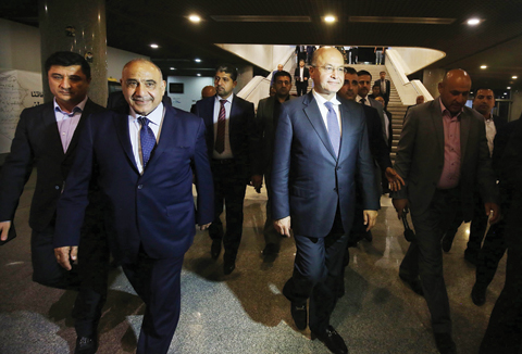 BAGHDAD: Newly designated Iraqi Prime Minister Adel Abdul Mahdi (center left) walks out of the parliament with newly-elected Iraqi President Barham Saleh (center right) late Tuesday. - AFP n