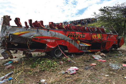 KERICHO, Kenya: Photo shows the wreckage of a bus at the site of an accident in Kericho, western Kenya yesterday. At least 50 people were killed when the bus they were travelling in overturned and its entire roof was ripped off, police said. — AFP