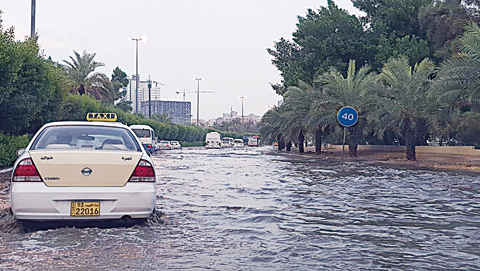 KUWAIT: Vehicles drive through a pool of rainwater in Fintas following yesterday’s rain showers. —Photo by Yasser Al-Zayyat