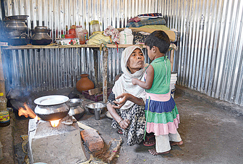BARUIPUR, India: In this file photo a Rohingya refugee cooks at a temporary shelter near the village of Baruipur, some 55km south of Kolkata.  -AFPn