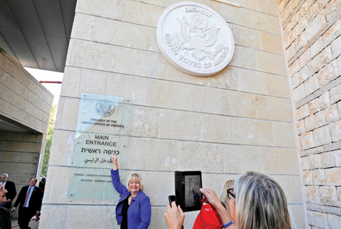 JERUSALEM: In this file photo, a woman poses for a picture next to an inauguration plaque during the opening of the US embassy in Jerusalem. — AFP
