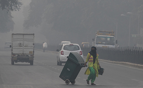 NEW DELHI: A sweeper cleans a road amid heavy smog in New Delhi yesterday - a day after the Diwali festival. Air pollution in New Delhi hit hazardous levels yesterday after a night of free-for-all Diwali fireworks, despite Supreme Court efforts to curb partying that fuels the Indian capital's toxic smog problem. - AFP 