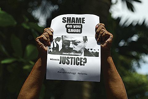 COLOMBO: A member of the Sri Lankan web journalist association holds a poster with the image of Saudi journalist Jamal Khashoggi during a demonstration outside the Saudi Embassy in Colombo. _ AFP 