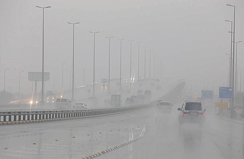 KUWAIT: Cars drive through rain and mist in stormy weather yesterday. — Photos by Yasser Al-Zayyat