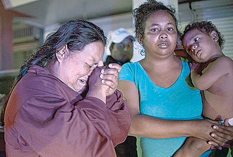MEXICALI: Zaira Fonseca from Honduras (left) cries while looking for her lost son in a shelter, in Mexicali, Baja California state, Mexico. —AFP